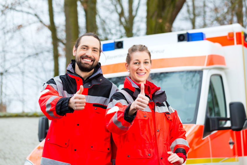 Zwei Rettungssanitäter vor einem Rettungswagen